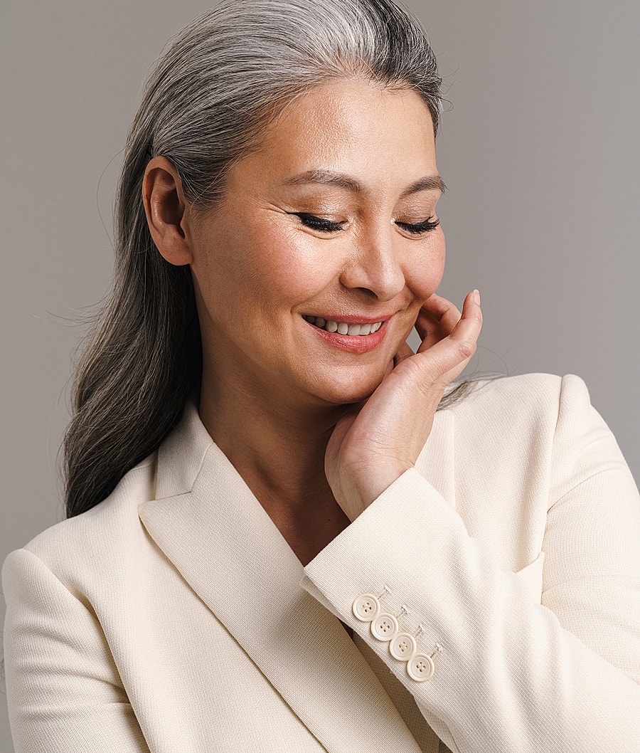 Smiling woman in a light-colored blazer.
