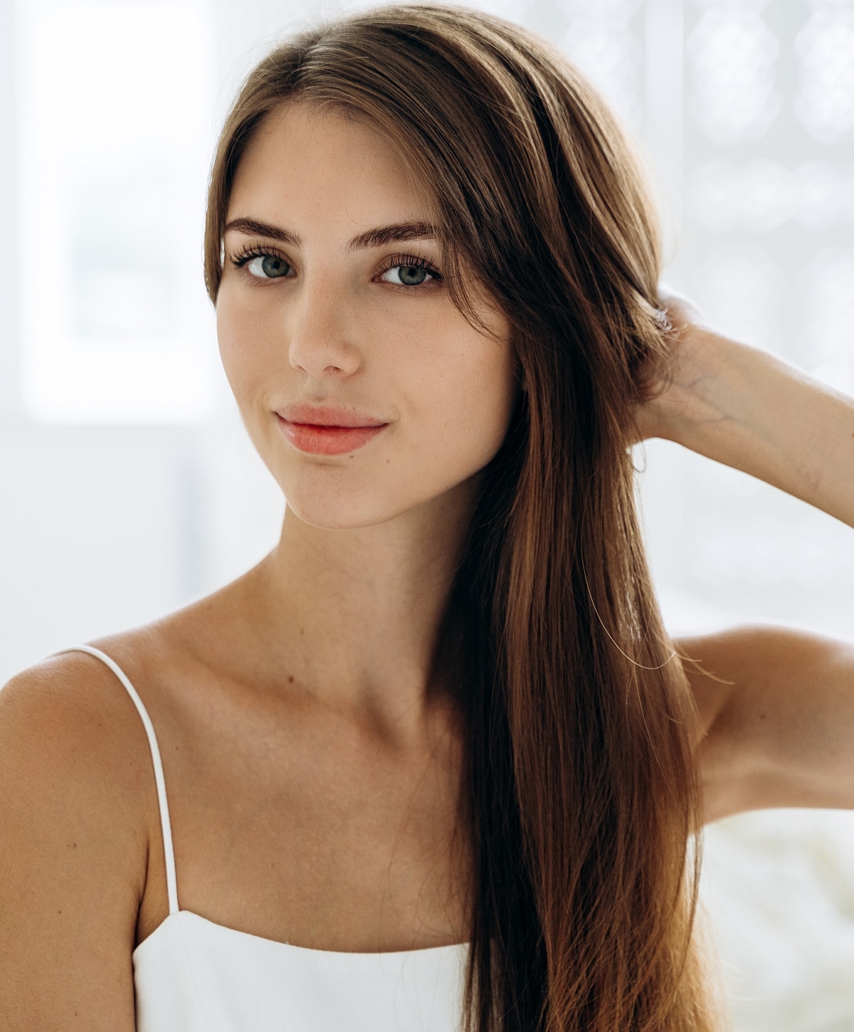Young woman with long hair and soft expression.