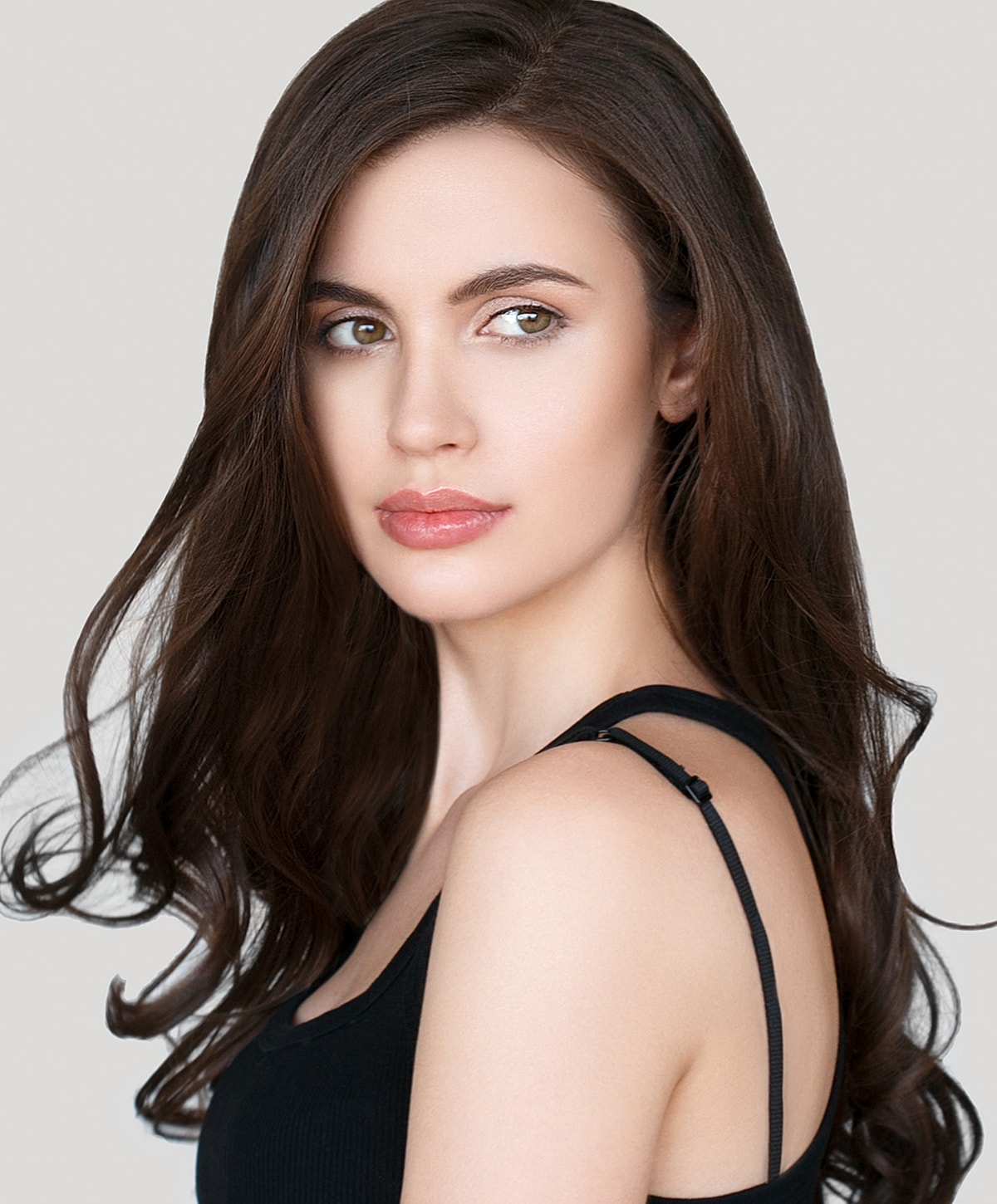 Woman with long hair against a neutral background.