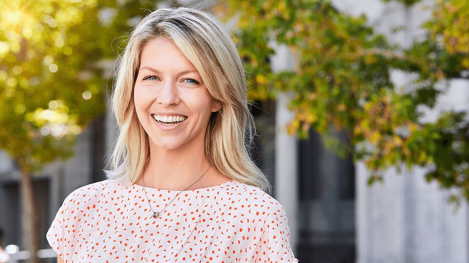 Smiling woman outdoors in a casual outfit.