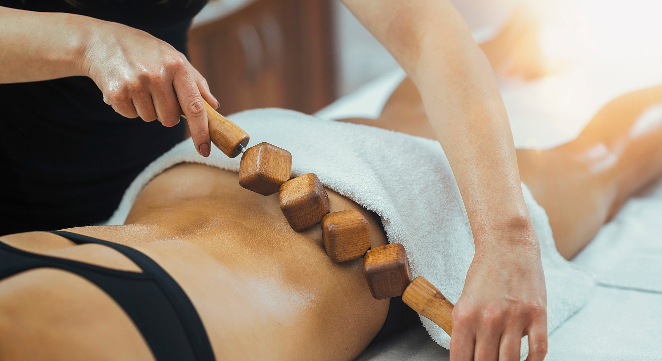 Massage therapy with wooden tools on back.